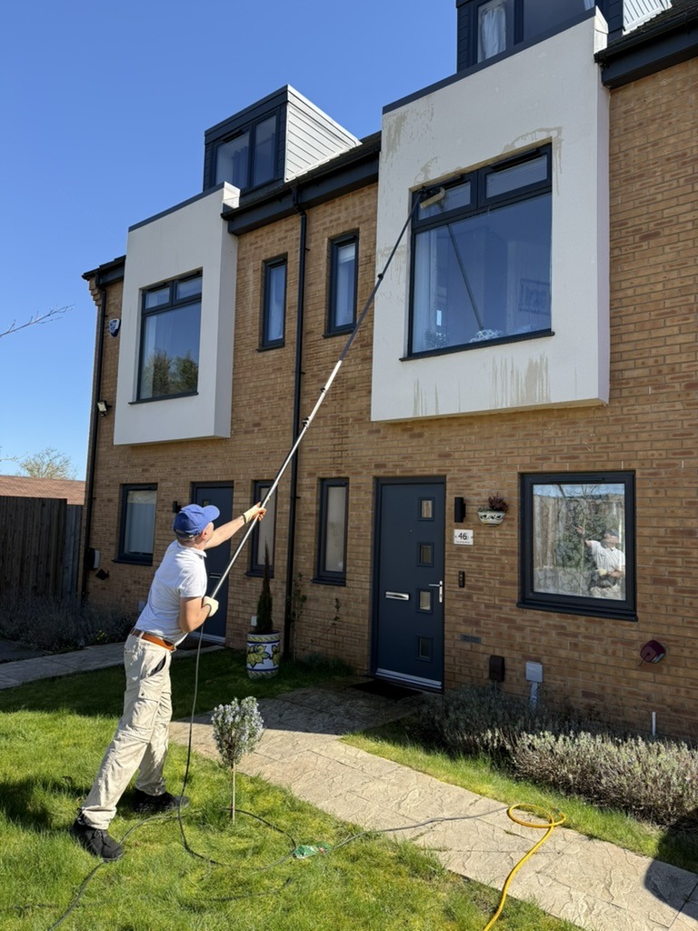 Hassan is cleaning a window on a three storey house.